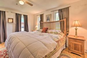 a bedroom with a bed and a lamp and windows at Pet-Friendly Roxbury Farmhouse on 350 Acres! in Roxbury