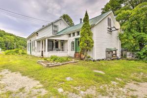 una vieja casa blanca con un patio en Pet-Friendly Roxbury Farmhouse on 350 Acres! en Roxbury