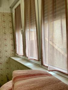 a bedroom with a window with pink curtains at La Quintana in La Espina