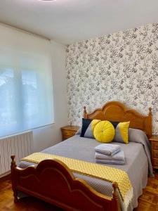 een slaapkamer met een bed met gele en blauwe kussens bij La Quintana in La Espina