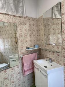 een badkamer met een wastafel, een toilet en een spiegel bij La Quintana in La Espina