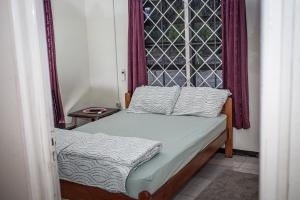 Dormitorio pequeño con cama y ventana en Sonja's Guesthouse en Zanderij