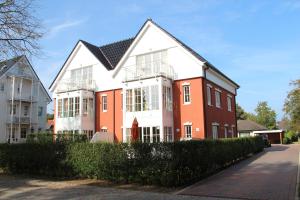 a large white and orange house on a street at Ferienwohnung Seeschwalbe in Südstrand