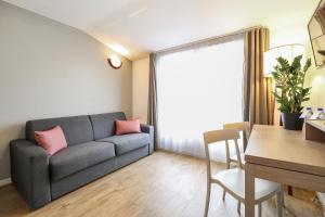 un soggiorno con divano e tavolo di Appart'City Confort Niort Centre a Niort