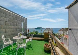 a balcony with a table and chairs and the ocean at Sea Spirit - Sweeping Sea Views first floor spacious modern apartment in Looe- with FREE parking! in Looe