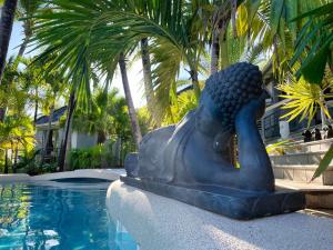 a statue sitting next to a swimming pool at Résidence Adam et Eve in Orient Bay