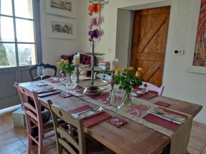 a dining room table with flowers on top of it at Les Houstalous in Lacombe