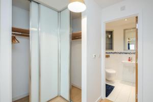 a bathroom with glass doors and a toilet at Cloud9SA at The Park Heights Woking in Woking