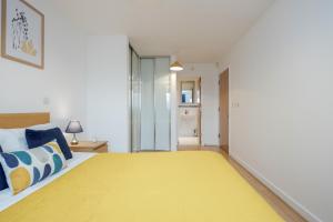 沃金的住宿－Cloud9SA at The Park Heights Woking，一间卧室配有一张带黄色毯子的大床
