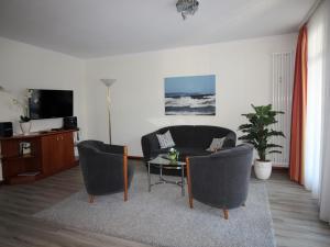 ein Wohnzimmer mit einem Sofa, einem Tisch und Stühlen in der Unterkunft Strandvillen Binz - Ferienwohnung mit Meerblick, 2 Schlafzimmern und Balkon SV-761 in Binz