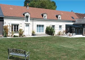 a white house with a bench in the yard at Sur La Route Des Châteaux in Thenay