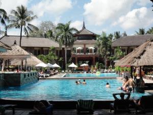 スミニャックにあるPrivate Apartment inside Beach Resort Jayakartaのリゾート内のプールで泳ぐ人々