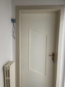 Una puerta blanca en una habitación con radiador en Dimora Nonna Ada, en Aradeo