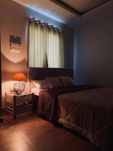 een slaapkamer met een bed en een tafel met een lamp bij SunsetHomes A luxurious studio apartment in Imphal