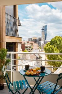 a table on a balcony with a view of a city at Hôtel Sanso by HappyCulture in Paris