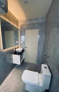 een badkamer met een wit toilet en een wastafel bij SunsetHomes A luxurious studio apartment in Imphal