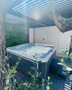 een hot tub onder een pergola naast een boom bij Suite tentation in Sorgues