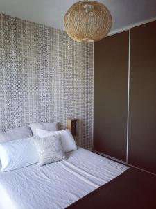 Chez Jo chambre d'hôtes في Montastruc-la-Conseillère: غرفة نوم بسرير ابيض كبير مع ثريا