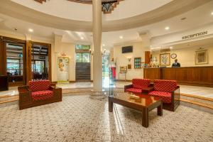 a lobby with red chairs and a table in a building at Kibo Palace Hotel Arusha in Arusha