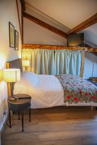 a bedroom with a bed and a table with a lamp at CROIX BLANCHE - LE LOGIS in Tournan-en-Brie