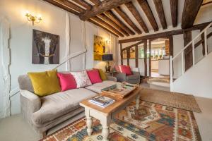 een woonkamer met een bank en een tafel bij Utterly divine romantic retreat in brilliant village - Tudor Cottage in Sudbury