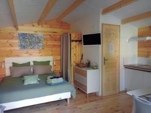 a bedroom with a bed and a desk in a room at Chalet Le Petit olivier , gite l Echapée Belle Aubenas in Aubenas