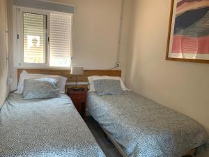 2 camas en una habitación pequeña con ventana en Casa La Cabezada, en San Sebastián de la Gomera