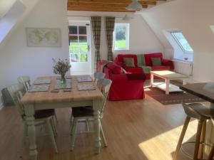 a living room with a table and a red couch at Stable Loft in Winscombe