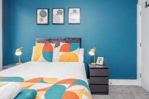 um quarto azul com uma cama e 2 candeeiros em Cloud9SA at The Charles Chertsey em Chertsey