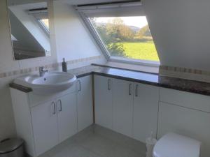 a bathroom with a sink and a window at Stable Loft in Winscombe