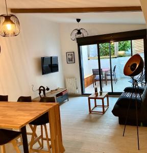 a living room with a table and a dining room at Le Flocmagny in Chalons en Champagne