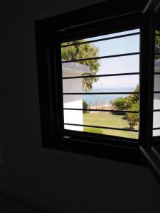 a window in a room looking out at the water at Σπίτι με σοφίτα μπροστά στη θάλασσα in Trápeza