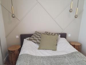 - une chambre avec un lit et deux tabourets en bois dans l'établissement Apartament Piaskowa Duna, à Mechelinki