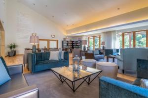 a living room with blue couches and a table at Hotel Rural Vale Do Rio in Oliveira de Azemeis