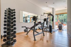 a gym with treadmills and weights in a house at Hotel Rural Vale Do Rio in Oliveira de Azemeis