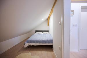 een kleine slaapkamer met een bed op zolder bij Apartment P42 in Slovenj Gradec