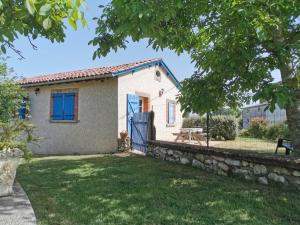 a small white house with a blue door at Les Genêts Valderois in Valderiès