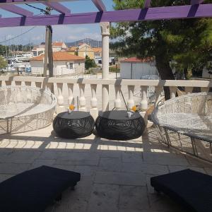 eine Terrasse mit 2 Tischen und Stühlen auf dem Balkon in der Unterkunft jardin kapetanova kuća in Veli Iž