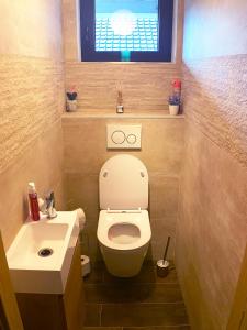 La salle de bains est pourvue de toilettes, d'un lavabo et d'une fenêtre. dans l'établissement Gîte Bella-K, logement privatif en campagne à Gesves, à Gesves