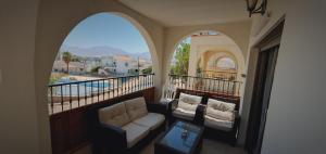 a balcony with a couch and a view of a pool at Riviera palace Eilat in Eilat
