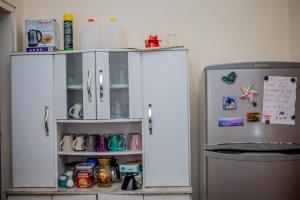 a kitchen with a white cabinet next to a refrigerator at Sonja's Guesthouse in Zanderij