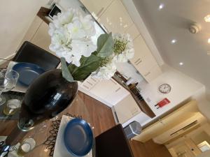 a vase with white flowers on a table in a kitchen at Cloud9SA at The Nankeville Woking in Woking