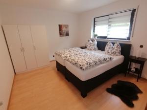 1 dormitorio con cama con almohadas y ventana en Ferienwohnung DORO en Kelberg