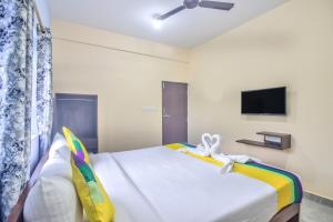 a bedroom with a large white bed with a tv at Crystal Bay Baga in Baga