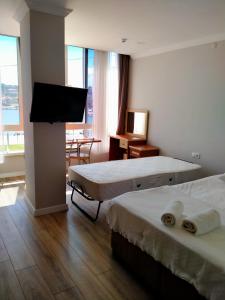 een hotelkamer met 2 bedden en een flatscreen-tv bij VENÜS PARK APART SUİTES in Çeşme