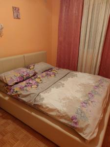 ein Bett mit Blumen darauf in einem Schlafzimmer in der Unterkunft Apartman UNA in Kruševac