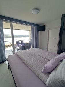 - une chambre avec un grand lit et une vue sur l'océan dans l'établissement Vila ČAROLIJA Futog, à Futog