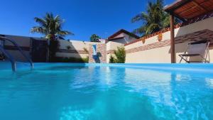 a swimming pool in front of a house at Pousada Anauê - Conde in Jacumã