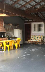 ein Wohnzimmer mit gelben Stühlen und einem Tisch in der Unterkunft Casa bem aconchegante! in Ubatuba