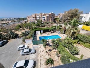 an aerial view of a parking lot with cars and a pool at Diamond Sea View Penthouse in Paphos